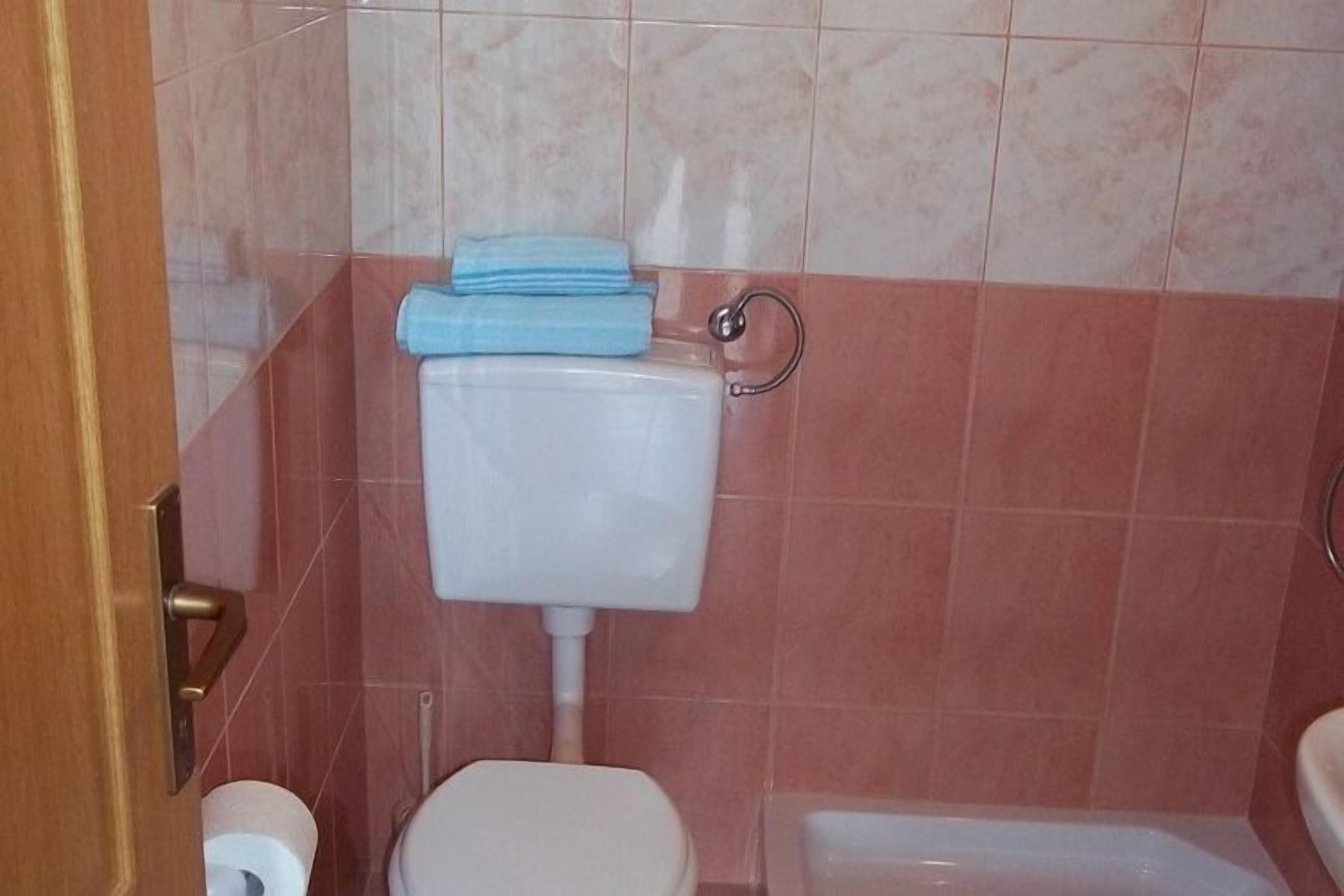 Une salle de bain avec des toilettes, un lavabo et une baignoire.
