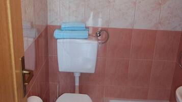 Une salle de bain avec des toilettes, un lavabo et une baignoire.