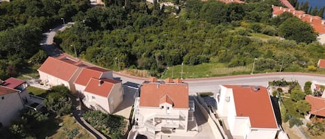 Vista aérea de una zona residencial costera con casas, una piscina y una carretera.