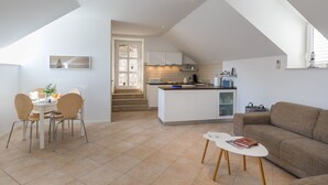 A modern apartment with a dining area, kitchen, and living space. - Apartments Odin - One-Bedroom Apartment with Terrace and Sea View - 4 (Dubrovnik)