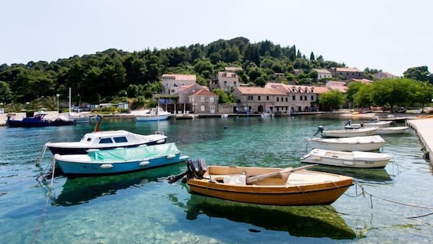A marina with several boats docked, surrounded by buildings and a hill in the background. - Guest House Simunovic - Double Room No3 (Sipanska Luka)