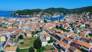 Une ville côtière où les bâtiments sont très rapprochés les uns des autres, avec une église imposante et un port de plaisance.