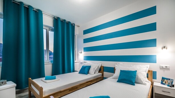 Une chambre d’hôtel avec deux lits, une fenêtre et une vue sur la ville.