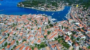 Vue aérienne d’une ville côtière avec des habitations densément regroupées, une marina et une baie.