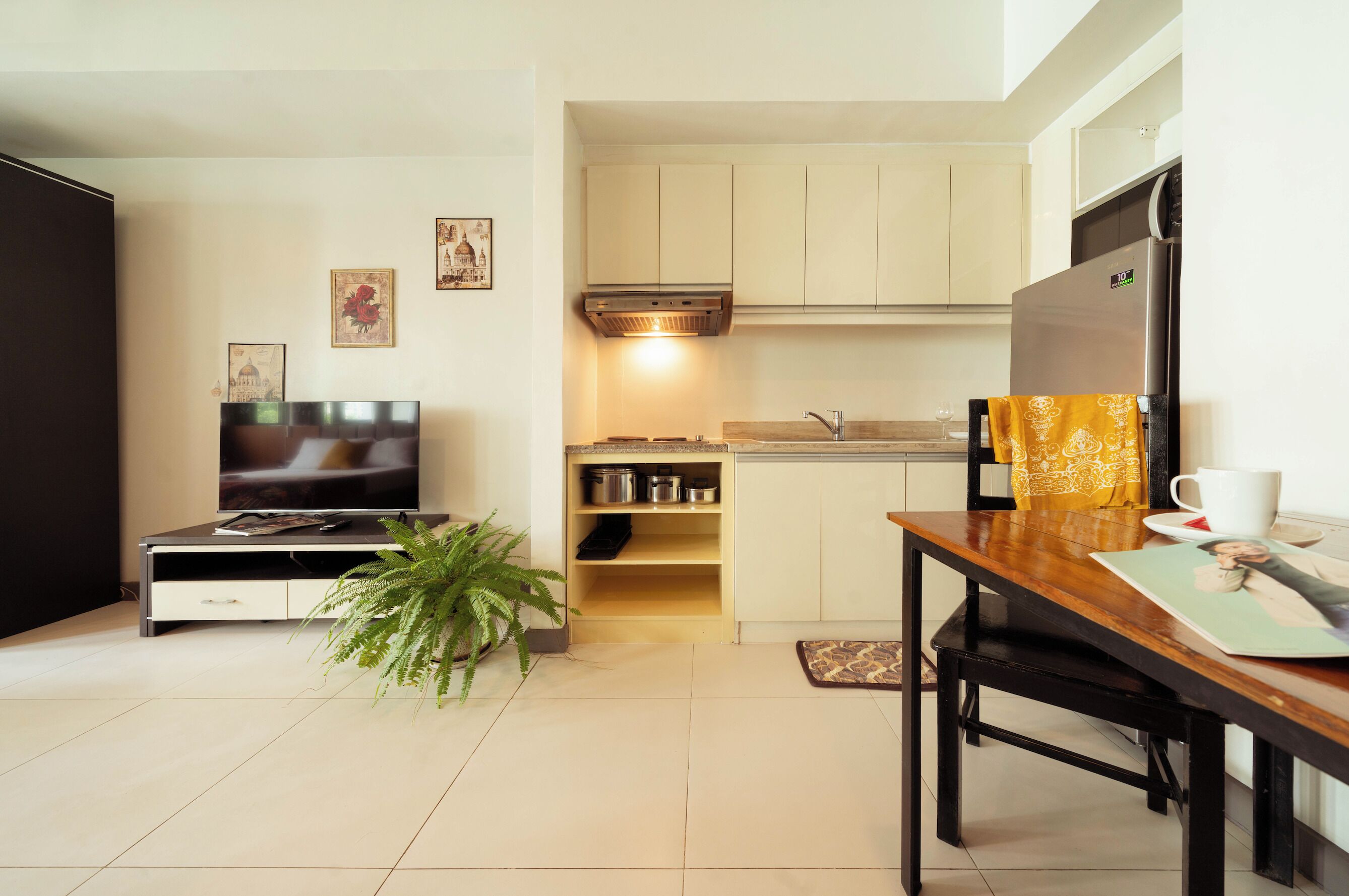 A compact living space with a kitchenette, a dining area, and a TV.