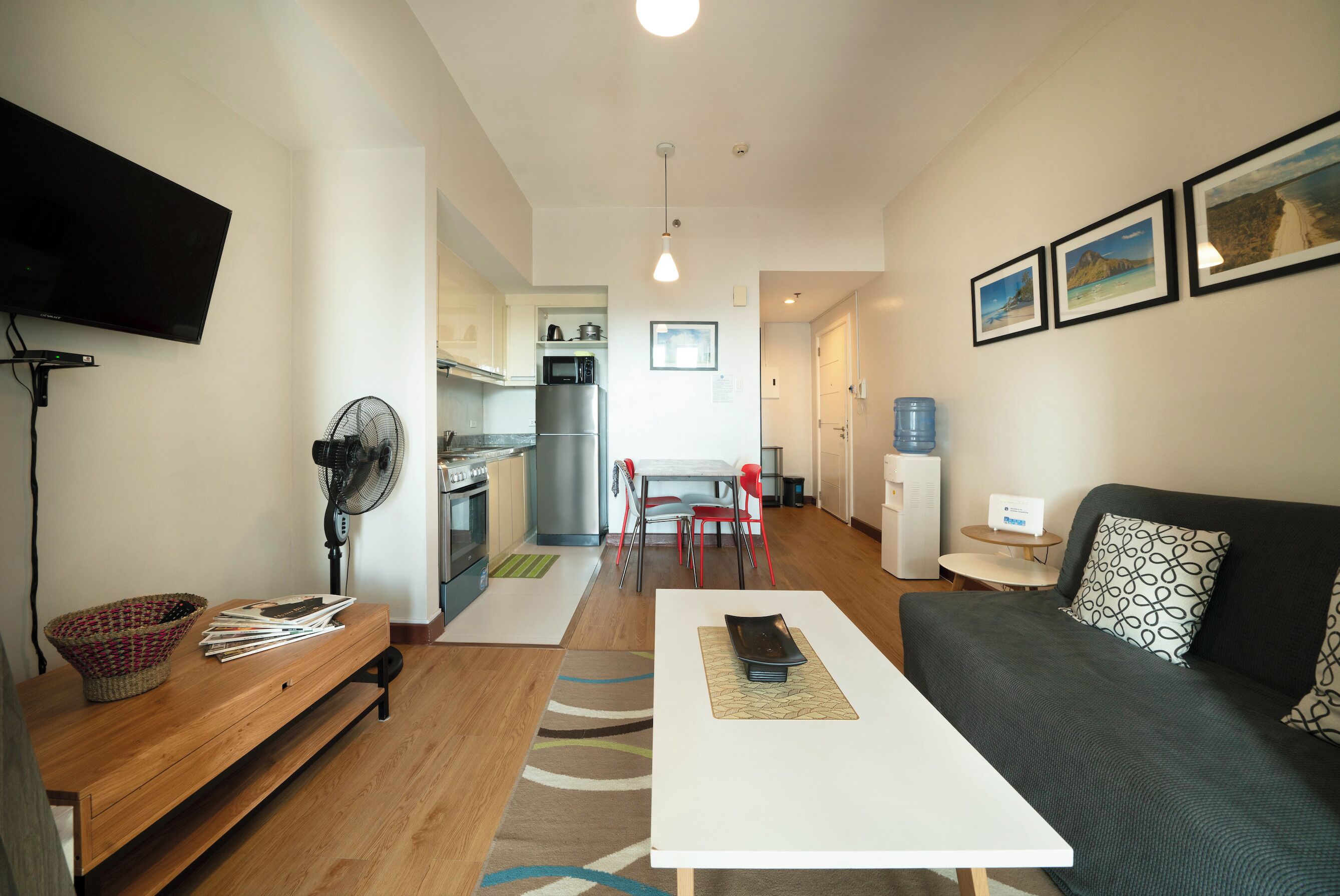 A modern living room with a sofa, a coffee table, and a TV mounted on the wall.