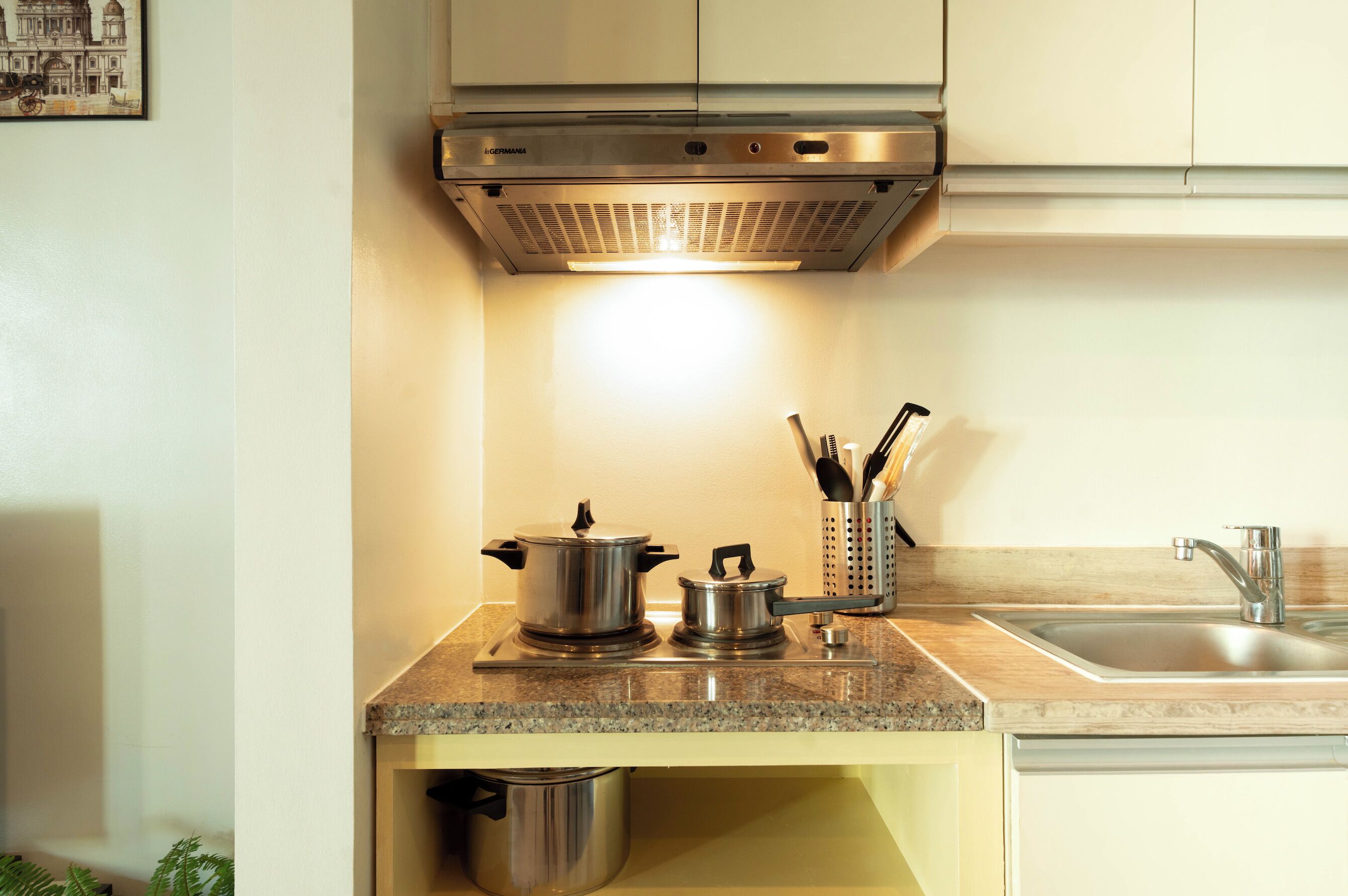 A kitchen with stainless steel appliances, a granite countertop, and a sink.