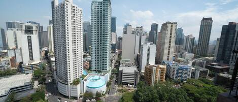 A high-rise building with a distinctive blue dome and a modern design, surrounded by other tall buildings in an urban setting.