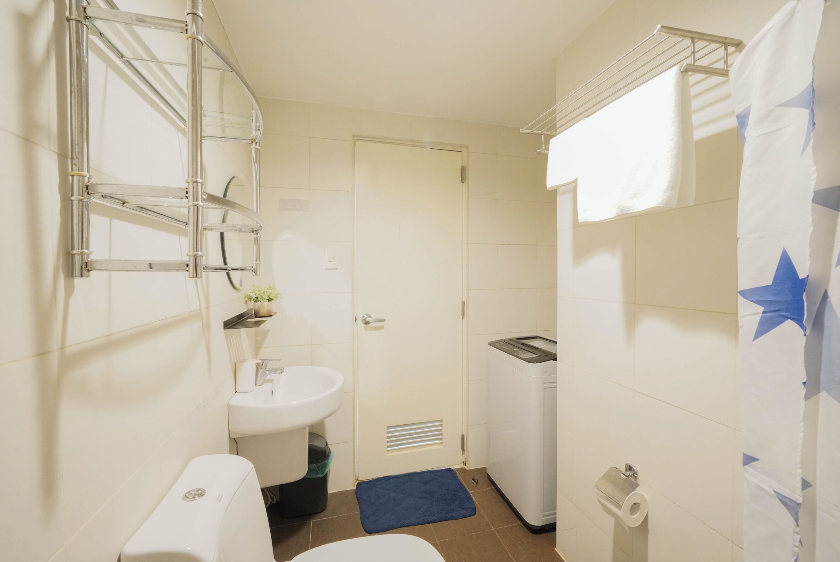 A compact bathroom with a toilet, sink, and washing machine.