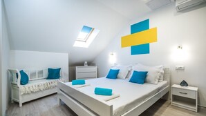 A modern bedroom with a large bed, a bench, and a nightstand. - Apartments & Rooms Sunshine Home - Studio Apartment (Vela Luka)