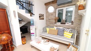 A modern living room with a white sofa, a coffee table, and a globe. - 1 bedroom apartment with terrace (Orebic)