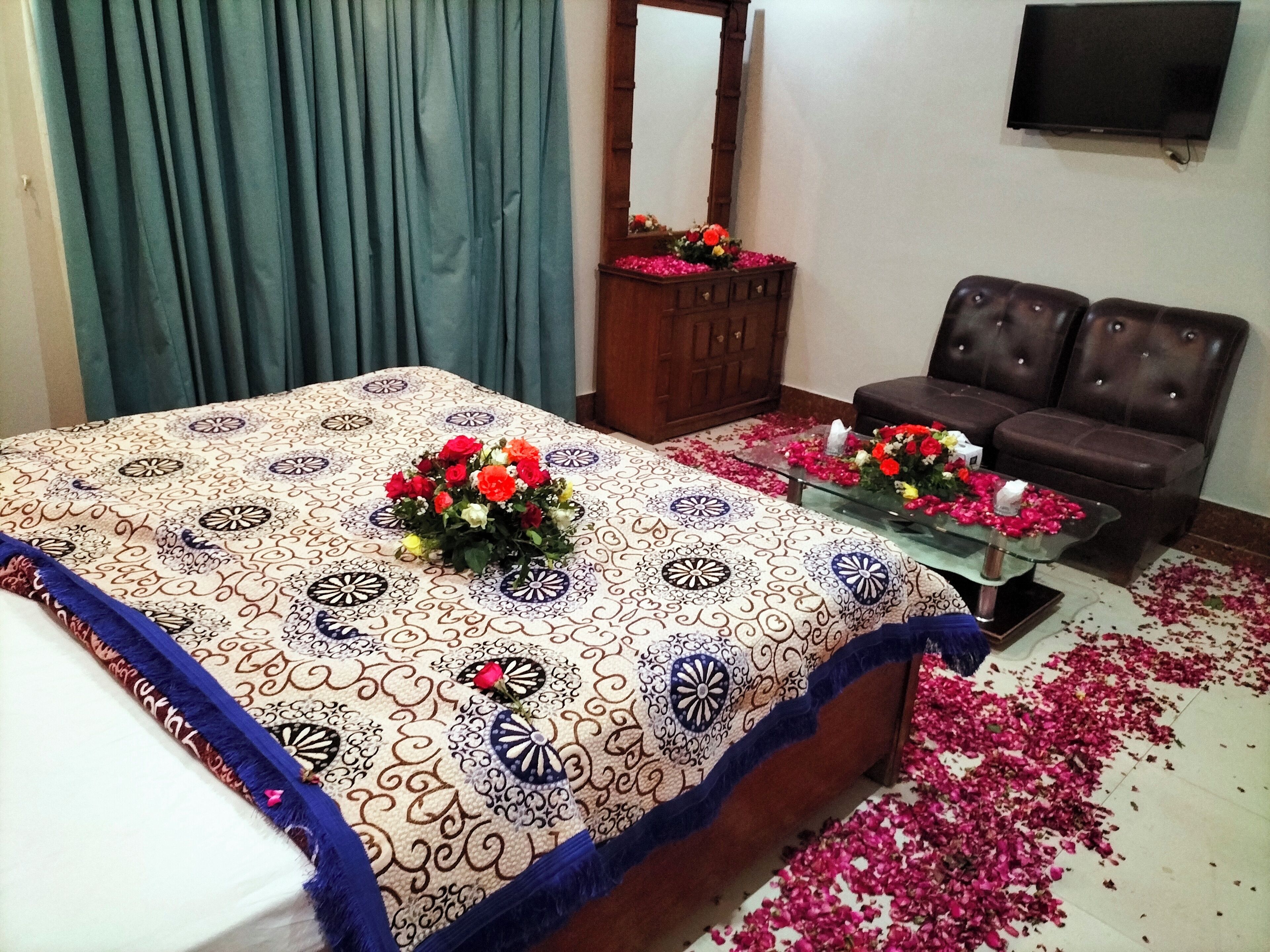 Una habitación de hotel con cama, sofá, televisor y espejo.