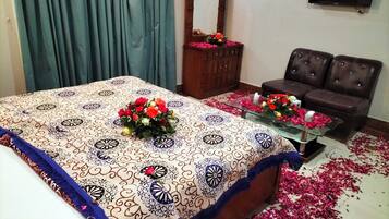 Una habitación de hotel con cama, sofá, televisor y espejo.
