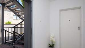A staircase leading to an outdoor area, a white door, and a potted orchid. - Apartments Dva Galeba - Standard One Bedroom Apartment with Terrace (101) (Bol)
