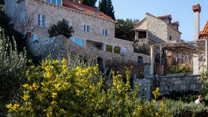 A stone building with multiple windows and a red-tiled roof. - Mali Skoj Apartment - Two-Bedroom Apartment with Sea View (Sudurad)