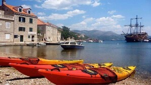 A waterfront scene with boats, a historic building, and a large ship in the background. - Mali Skoj Apartment - Two-Bedroom Apartment with Sea View (Sudurad)