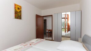 Ein Schlafzimmer mit Bett, Schrank und einem Bild an der Wand.