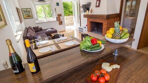 Una cocina moderna con una isla de madera, un área de comedor con un sofá y una chimenea.