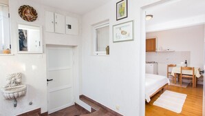 Un dormitorio con cama, escritorio y silla. Hay una ventana y una puerta.