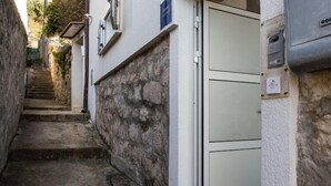 Una estrecha escalera de piedra que conduce a una puerta con un panel verde claro.