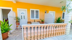 A patio area with a white table and chairs, potted plants, and a white balustrade. - Apartments Ivana (TR) -Studio with Terrace ( A2) (Trogir)