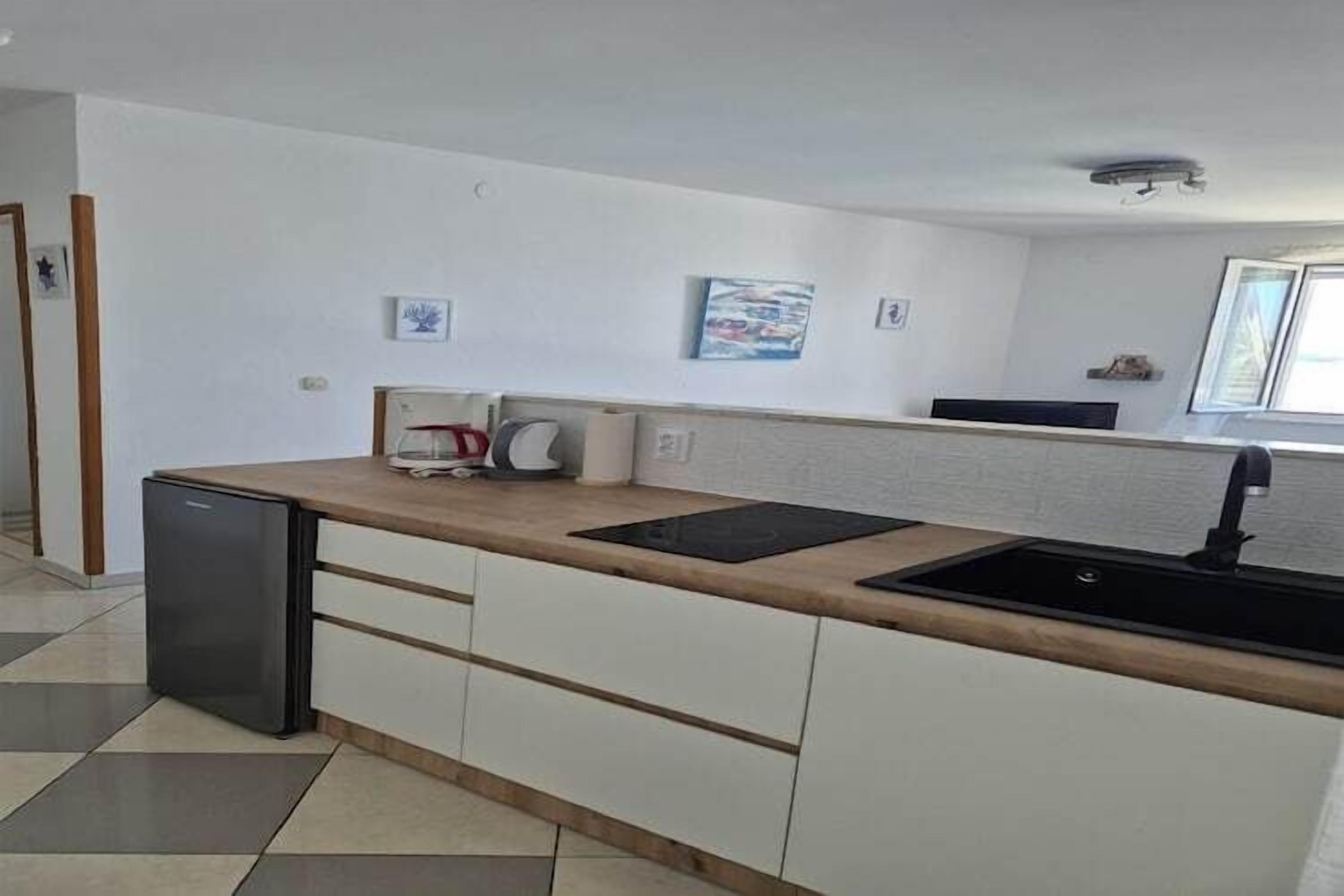 Eine moderne Küche mit Spüle, Arbeitsplatte und einem kleinen Kühlschrank.