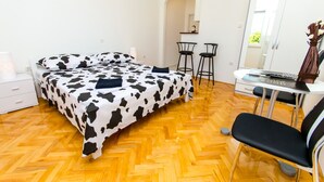 Une chambre à coucher avec un lit, un bureau, deux chaises et un miroir.