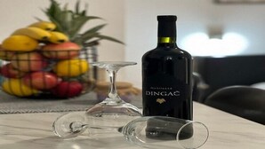 A bottle of DINGAC on a table with two empty wine glasses. - Apartments Noa Old Town - Studio - First Floor (Dubrovnik)