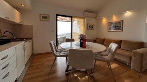 Una cocina moderna con comedor, sofá y vistas a través de un ventanal.
