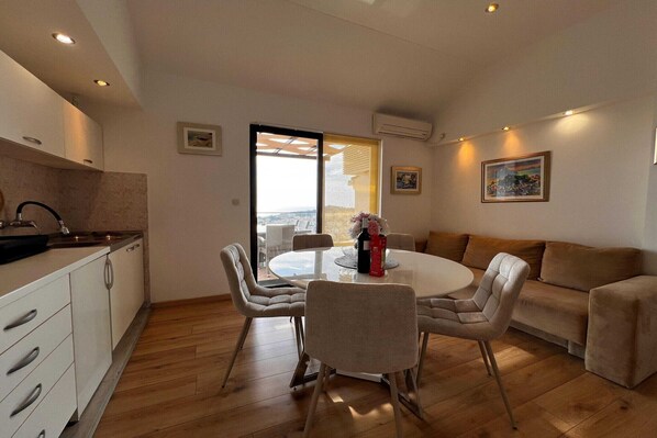 Una cocina moderna con comedor, sofá y vistas a través de un ventanal.