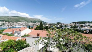Un paysage urbain côtier avec des bâtiments, une colline et un ciel dégagé.
