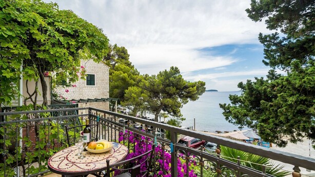 Ein Balkon mit Tisch für zwei Personen, mit Blick auf die Küste.