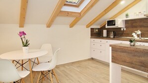 Cocina moderna con tragaluz, armarios blancos y encimera de madera.