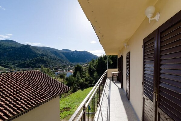 Un balcón con vistas a montañas y un valle.