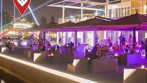 An outdoor seating area with modern furniture and a covered section, likely part of a hotel or resort.