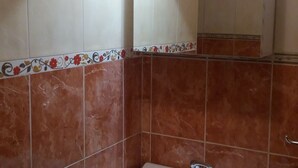 Een badkamer met marmeren tegels en een decoratieve rand.