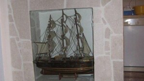 Een model van een schip op een stenen muur.