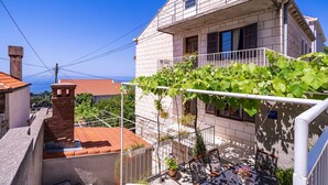 Un edificio residencial con balcón, chimenea de ladrillo y vista al mar.