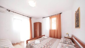 Un dormitorio con cama, armario y mesita de noche con lámpara.