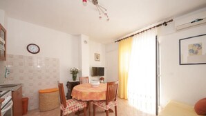 Una cocina compacta con mesa, sillas y un pequeño comedor.