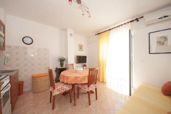 A compact kitchen with a dining table, chairs, and a small dining area.