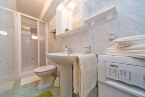 Ein modernes Badezimmer mit Toilette, Waschbecken und Duschkabine.