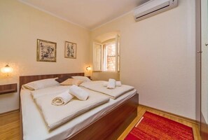 Ein Hotelzimmer mit zwei Betten, einem roten Teppich und zwei Wandlampen.