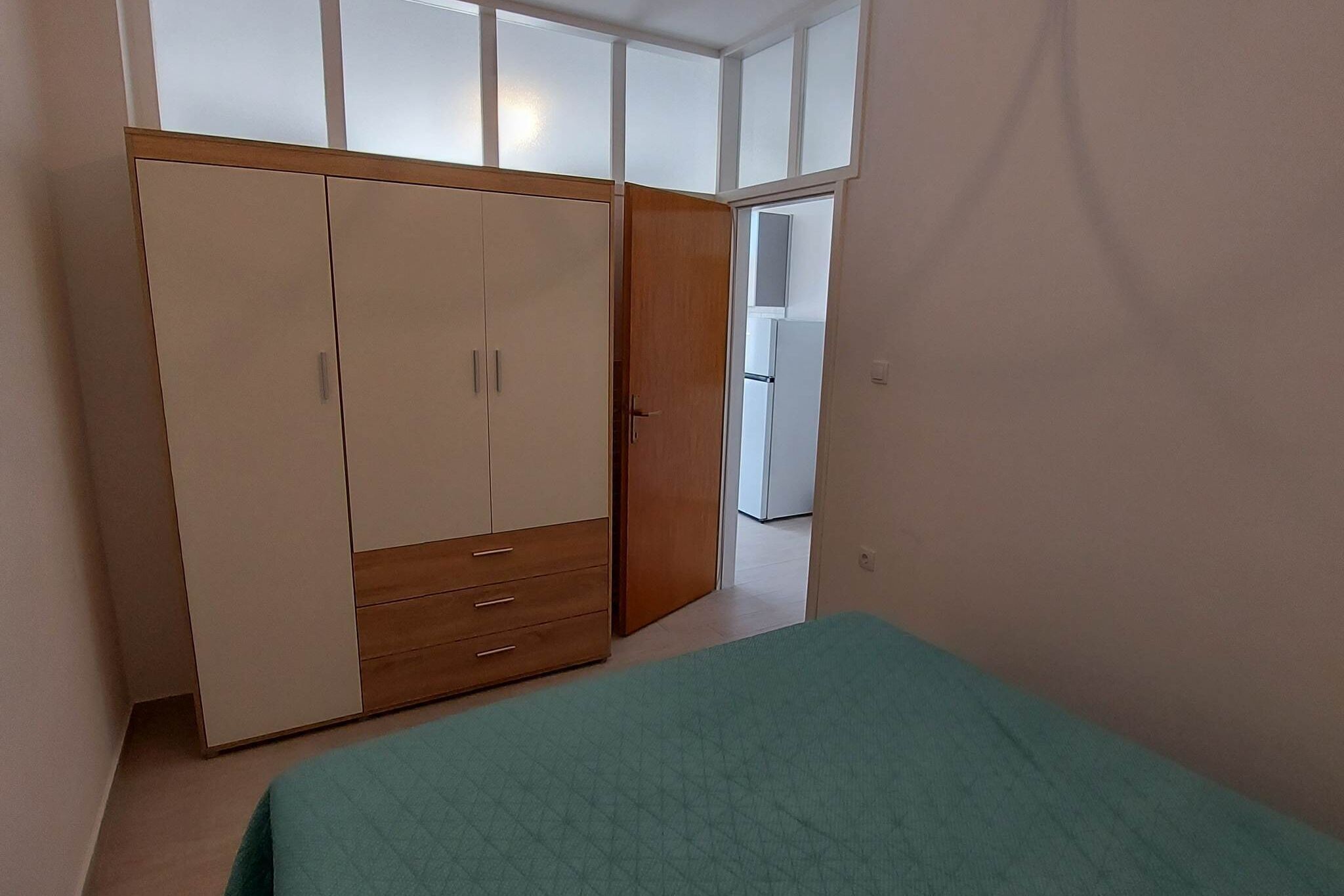 Une chambre à coucher avec un lit, une armoire et une vue par la fenêtre.