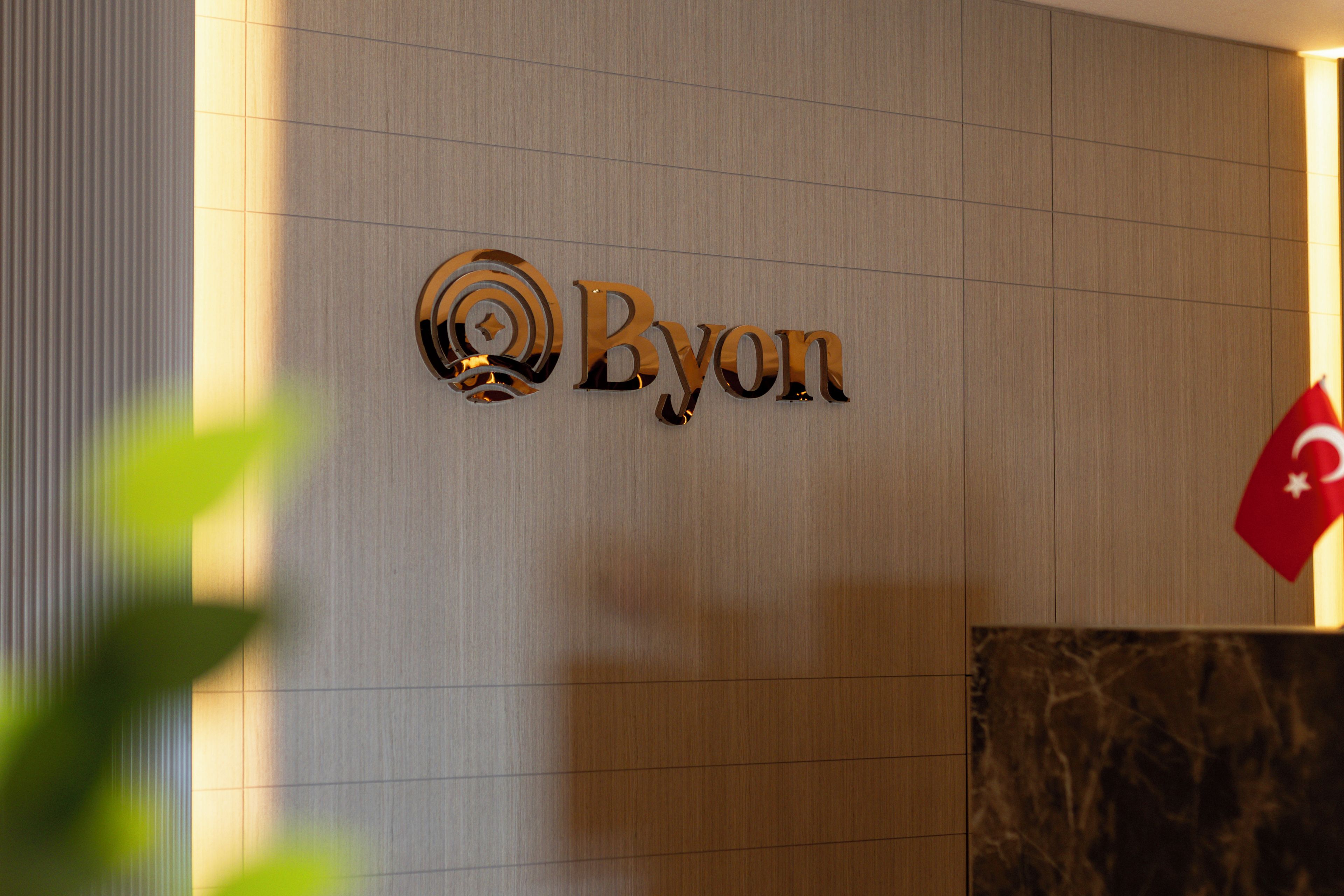 Una pared con el logotipo 'Byon' y una bandera.
