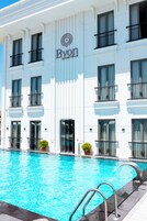 Un hotel con piscina, un cartel que dice 'Byron Hotels' y un diseño arquitectónico moderno.