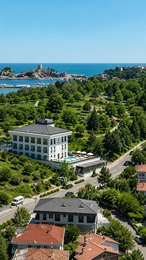 A hotel with a pool, surrounded by greenery and a view of the sea. - Byon Hotel Şile (Sile)