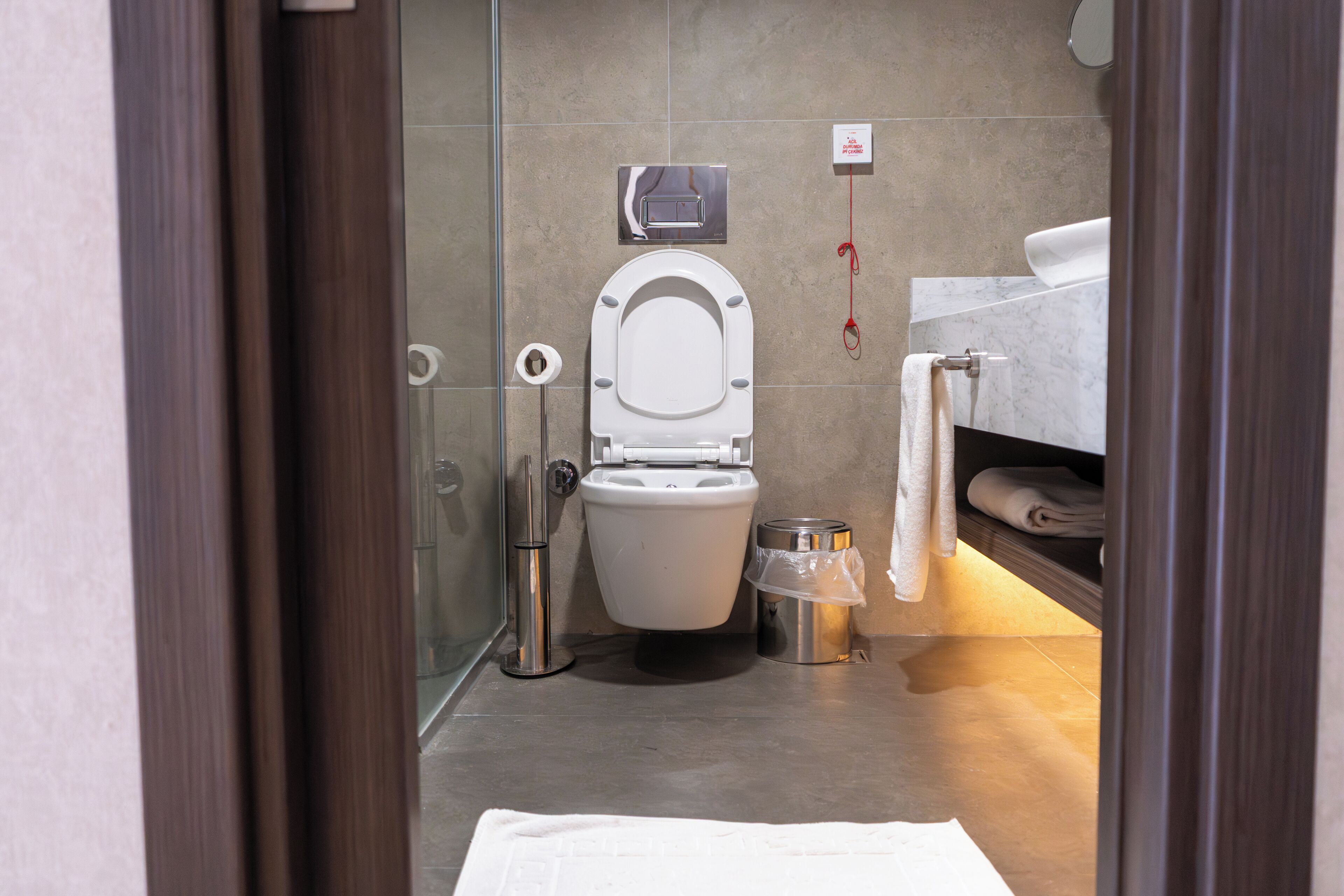 Une salle de bain moderne équipée de toilettes, d’un bidet et d’un porte-serviettes.