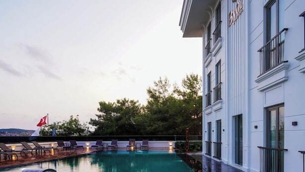 A hotel with a swimming pool, wooden deck, and a flag. - Byon Hotel Şile (Sile)