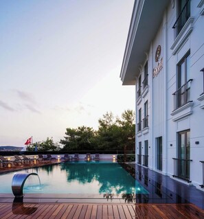 A hotel with a swimming pool, wooden deck, and a flag. - Byon Hotel Şile (Sile)